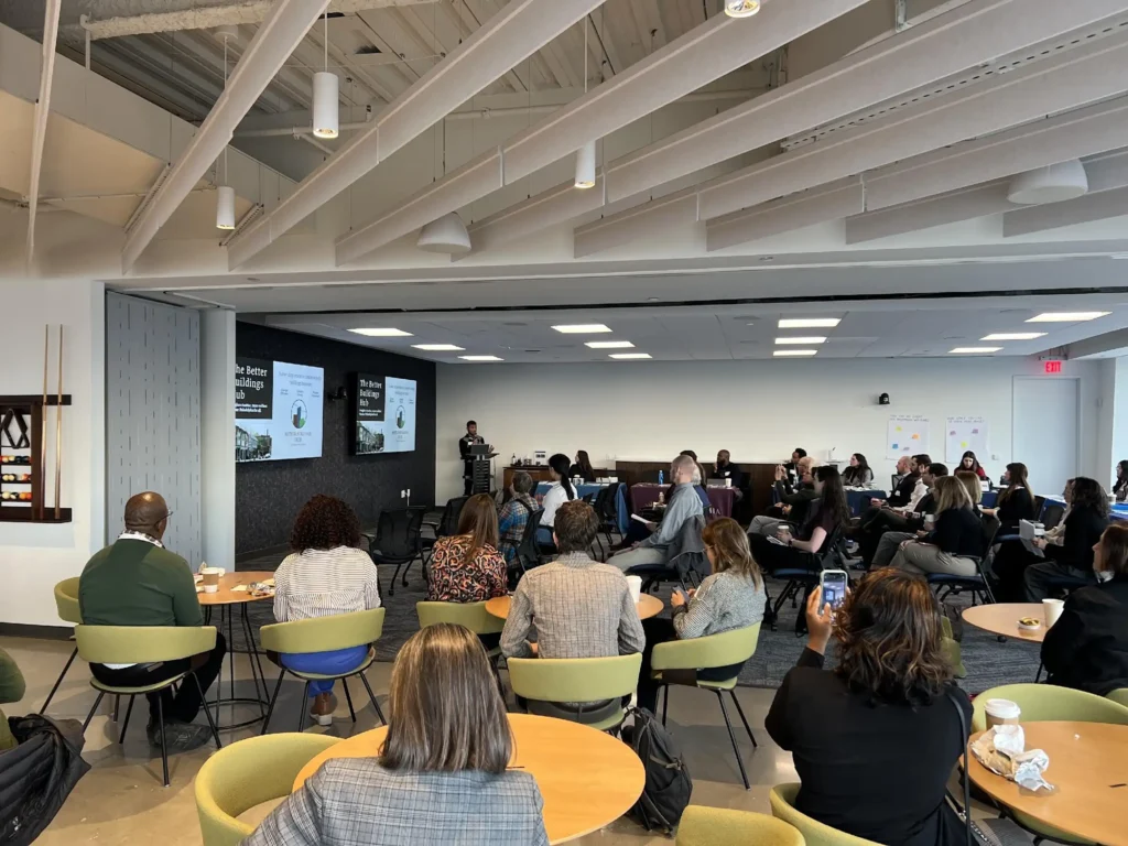 Better Buildings Hub event with speaker at podium and attendees sitting at tables